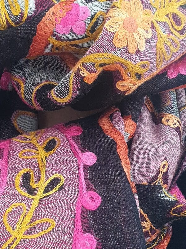 bufanda artesanal bordada en tonos morados y rosas